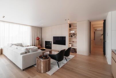 Maatwerk haardwand in microtopping en houtfineer door Degraer Interieurarchitect, Kortrijk